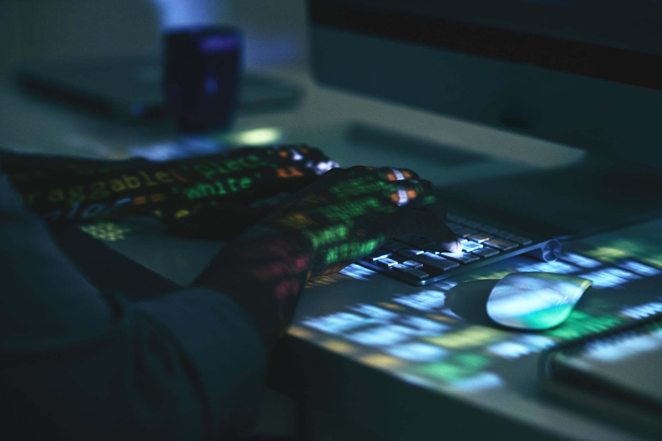 Developer typing code with projected data on hands and keyboard